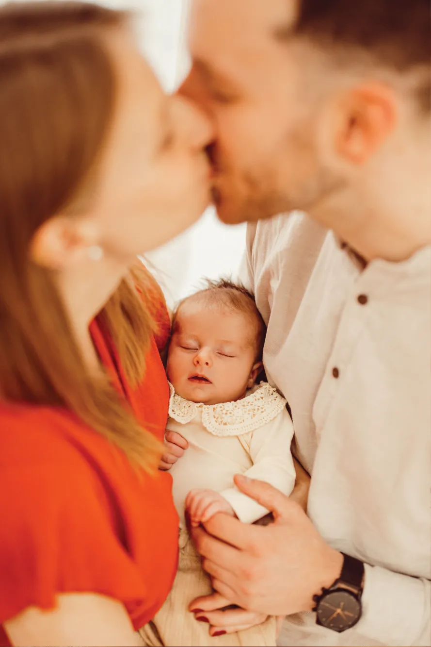 Eltern küssen sich, Baby in der Mitte