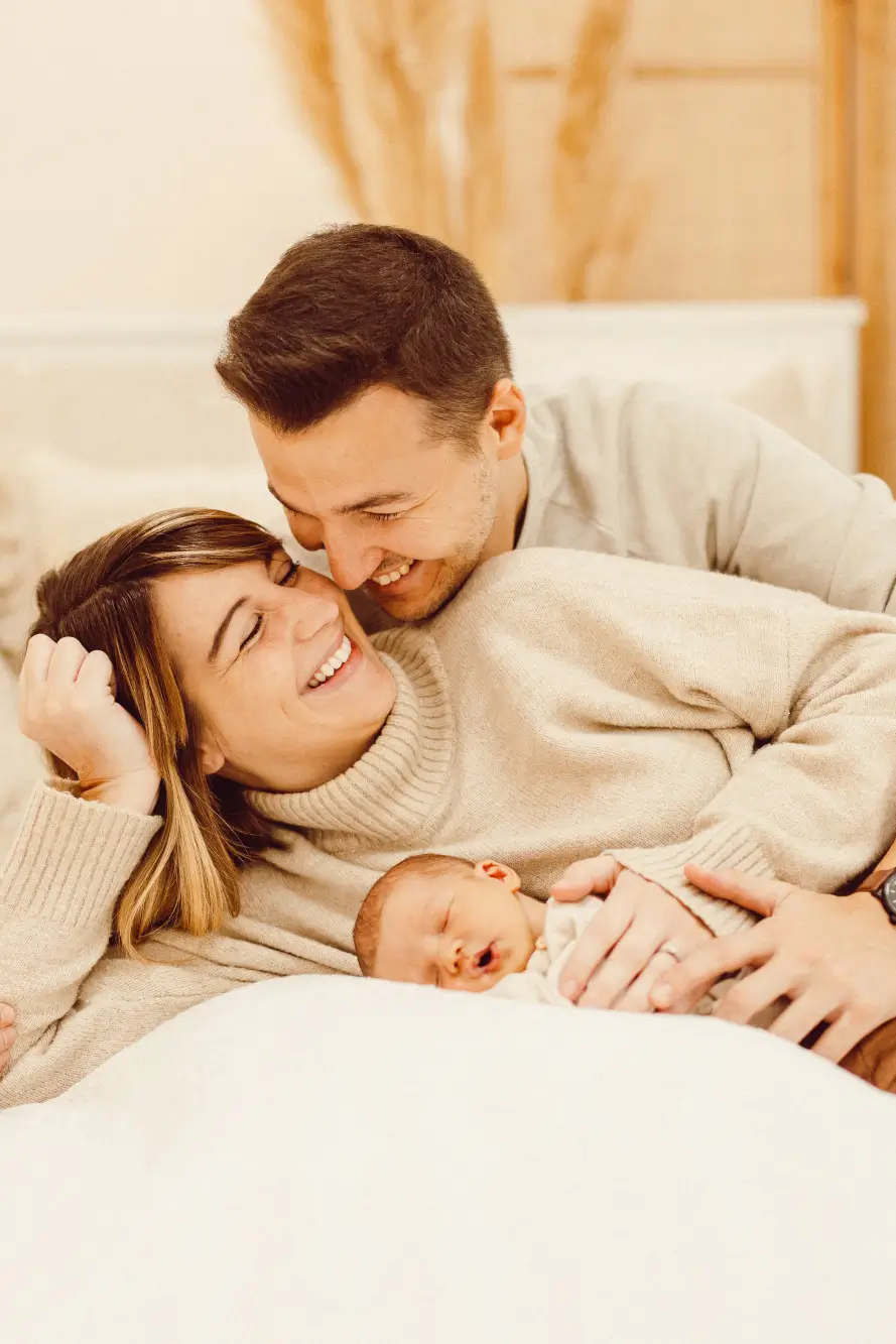 Eltern halten ihr Baby zusammen sehr eng und sind sehr fröhlich