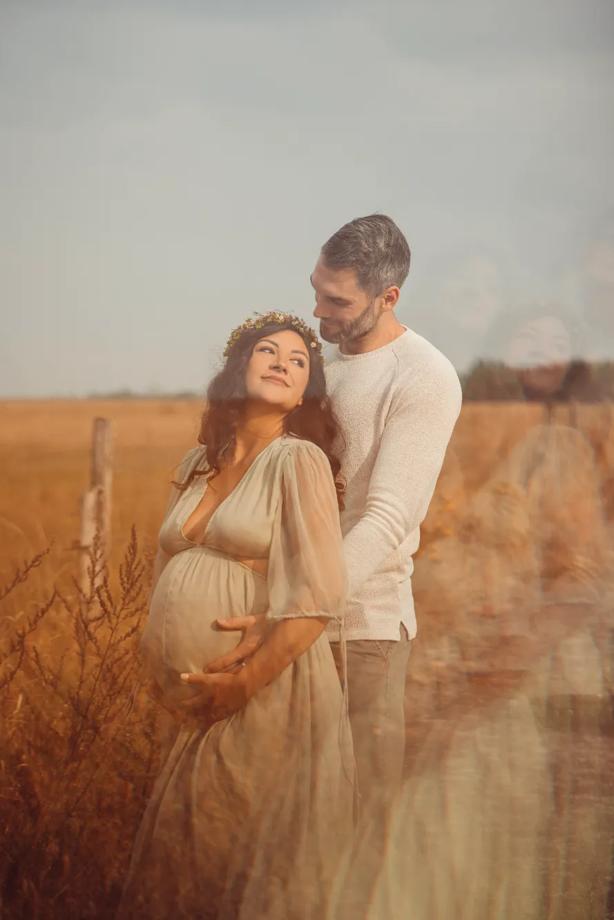 Ein Päärchen in der Natur. Mann und Frau halten den Babybauch